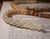 Close up of Momi shells in double double Pikake style showing creamy off white Keʻokeʻo tones, detailed Niʻihau shell jewelry craftsmanship in traditional Hawaiian lei design