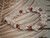 Niʻihau shell bracelet kipona style 7.5 inch detailed front view with momi shells and kahelelani shells red burgundy green accents #395