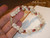 7.5" Niʻihau shell bracelet kipona style shown on hand with momi shells and kahelelani shells red burgundy green pink flower accents #395