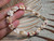 Niihau shell bracelet in hand size comparison Kipona style with Momi shells off white light blue undertone and Kahelelani shells red black green pink dainty Hawaiian jewelry