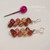 nier_3164
Kahelelani shell earrings lay flat with head pin showing size comparison of tiny shells, featuring burgundy soft pink and light green tones, tiny colorful Hawaiian shell jewelry gift under $100