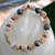 nibl_399
Niʻihau Momi and Kahelelani shell bracelet worn on wrist in crown flower design with Tahitian pearls, natural Hawaiian shell jewelry in soft earthy tones