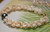 Side view Niihau Momi shell bracelet showing detail of tiny shells used to create Pikake tying technique, ombre yellow and off white tones, handcrafted Hawaiian shell jewelry using shells from Niihau island