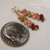 Tiny Niihau Kamoa shell earrings shown next to a dime for size comparison, featuring burgundy, pink, yellow kamoa, green and keokeo size 11 shells in a 3/4 inch drop design, Niihau shell gift under $100 with 14k gold filled hooks.