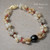Full view Hawaiian shell bracelet with Momi and Kahelelani shells in Kipona style, 10.23mm Tahitian pearl centerpiece and 14k gold filled clasp, handmade Hawaiian shell jewelry using traditional Kipona style technique, unique island gift