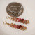 Kahelelani shell earrings from Kauai shown next to a coin for size comparison, small colorful Hawaiian shell earrings for gift, handmade Hawaiian shell jewelry with natural island tones
