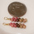 Mini Niihau shell earrings gift shown next to a coin for size comparison, Kahelelani shells in keokeʻo, pink, brown and green tones, small Hawaiian shell earrings under $100