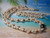 ninl_2011
This Niihau shell jewelry set features an 18 3/4" necklace and matching earrings in Kipona style using Momi and Kahelelani shells in light uliuli, pink flower, red, brown, and soft pink tones. The design includes a 10.84mm baroque Tahitian pearl in peacock color, finished with a 14k gold filled safety clasp and 14k gold filled earrings hooks, making it a beautiful gift under $1500.