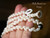 Hand holding traditional Momi shell necklace from Niʻihau featuring off white Hawaiian shells, peacock Tahitian pearl, and handmade puka shell clasp detail. Elegant Hawaiian shell necklace and authentic Niʻihau shell lei gift under $200.