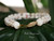 Close up clasp photo of handcrafted Niʻihau shell bracelet showing detailed 14k gold filled safety clasp and traditional shell tying craftsmanship with genuine Momi and Kahelelani shells.