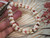 nibl_504
Close up Kipona style shell bracelet shown on hand before adding clasp, featuring genuine off white Momi shells with red, pink, brown, and black Kahelelani shell accents. Photo highlights the quality of the shells, detailed workmanship, and the balanced flow of shell colors and sizes throughout the bracelet.