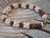 Authentic Hawaiian shell bracelet handcrafted with creamy yellow Momi shells and rich burgundy Kahelelani shells featuring traditional shellwork and decorative gold filled clasp detail.