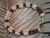 Genuine Hawaiian shell bracelet made with yellow Momi shells from Niʻihau and burgundy Kahelelani shells from Kauaʻi in an elegant traditional shell jewelry design. Close-up overall look featuring creamy yellow, off white, and deep burgundy shell colors with detailed handcrafted shellwork.