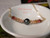 Elegant luxury island jewelry resting in a white dish. This genuine shell jewelry from Hawaii showcases a 9 mm Tahitian pearl surrounded by delicate, hand-sorted Kahelelani shells, ready to be gifted.