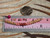 pd_601
Genuine Kahelelani shell necklace from Niʻihau shown beside a ruler for size reference featuring natural green, pink flower, and deep red burgundy shell colors in a refined minimalist design.