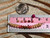 Genuine Kahelelani shell necklace from Niʻihau shown beside a ruler and coin for size reference featuring green, pink, red, brown, and black shell colors in a refined ombré design.