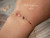 Minimalist Niʻihau shell bracelet worn on wrist featuring genuine Kahelelani shells with soft natural ocean colors and delicate 14k gold filled chain. Elegant everyday Hawaiian shell jewelry with understated coastal luxury and island-inspired style.