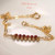 Authentic Niʻihau shell bracelet displayed on a white dish featuring genuine Kahelelani shells in ʻōmaʻomaʻo green and mākuʻe brown tones accented with delicate 14k gold filled chain. Elegant handcrafted Hawaiian shell jewelry with refined minimalist island style.