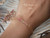 Pink ombré Kahelelani Hawaiian shell bracelet worn on wrist featuring genuine Niʻihau shells in soft ʻākala pua pink flower, ʻōmaʻomaʻo green, and keʻokeʻo tones. Elegant everyday Hawaiian jewelry with delicate coastal style and refined island inspired design.
