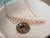 Rare Hawaiian shell necklace displayed on white dish featuring thick layered size 15 Kahelelani shells from Niʻihau in creamy ice-cream kamoa and soft keʻokeʻo tones accented with delicate gold filled chain. Elegant handcrafted island jewelry showcasing rare difficult-to-find Hawaiian shells.