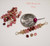 Coin guide photo showing the size of a handcrafted 1" Niʻihau modern design necklace beside a U.S. dime, featuring genuine size 11 Kahelelani shells in Keʻokeʻo white, green, pink flower, and red burgundy colors on 14K gold filled wire with a delicate tropical style.