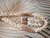 Close-up of matching Niʻihau Kipona earrings beside the coordinating center section of the handcrafted shell necklace, highlighting the balanced jewelry design.
