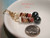 Size comparison of authentic Niʻihau shell earrings handcrafted in a Double Manuʻa Loa style with genuine Kahelelani shells, dark semi-round Tahitian pearls, and 14k gold filled ear hooks, shown beside a U.S. quarter.