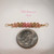 pd_756
Close-up of genuine Niʻihau Kahelelani shells in white, green and pink flower colors arranged for a handmade Hawaiian minimalist shell necklace, shown beside a dime for size comparison.