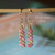 nier_3661
Dainty Niʻihau Kahelelani shell earrings #3661 with pink flower and green size 10 shells, shown hanging to display how the earrings fall.
