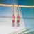 nier_3662
Dainty Niʻihau Kahelelani shell earrings #3662 hanging to show how the earrings hang, handcrafted with tiny size 10 brown, green and pink shells and 14K gold filled hooks.