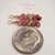 Dainty Niʻihau Kahelelani shell earrings #3665 hanging to show how the earrings hang, handcrafted with red burgundy, green and pink shells and 14K gold filled hooks.