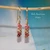 nier_3665
Close-up of Hawaiian Island minimalist shell earrings #3665 beside a U.S. dime for size comparison, featuring tiny size 10 red burgundy, green and pink Niʻihau Kahelelani shells.