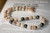 Full display of the Niʻihau shell lei with brown granulate cowrie shells before the clasp is finished, featuring Momi, Kahelelani and dark Tahitian pearls in a unique Hawaiian island jewelry design.