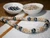 Close-up side angle of Niʻihau Momi shells and dark Edison pearls showing shell colors and iridescent pearl overtones