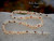 Full display of Niʻihau Momi and Kahelelani Kipona style shell lei before adding the clasp, showing the natural twisting pattern and mixed shell colors.