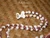 Close-up of white Niihau Momi and burgundy Kauai Kahelelani shells with natural Puka shell clasp on Hawaiian shell lei #2030