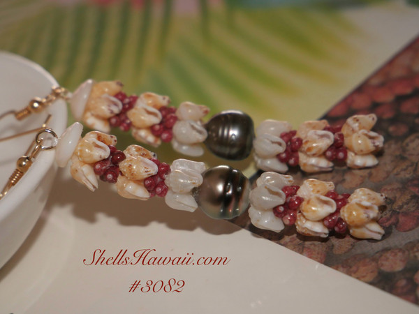 Close-up of four-strand Kipona style earrings showing alternating shells of yellow, blue, and burgundy red, each strand matched for texture and hue. Finished with a luminous 9 mm+ Tahitian pearl.