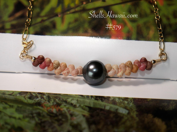 PD_579
A minimalist Hawaiian shell necklace with a Tahitian pearl centerpiece, displayed on a book cover. This authentic shell jewelry from Hawaii features a floating pattern of hand-sorted Kahelelani shells on a fancy Italian 14k gold-filled chain.