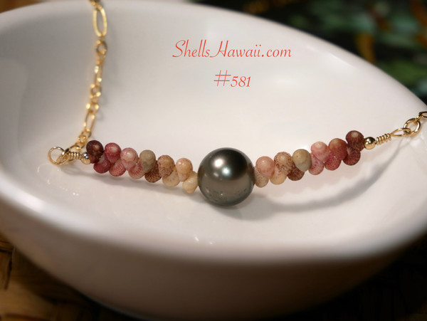 PD_581
A center view of this artisan shell jewelry resting in a white dish, displaying the soft ombre design of genuine Kauaʻi Kahelelani shells surrounding the luminous pearl centerpiece.