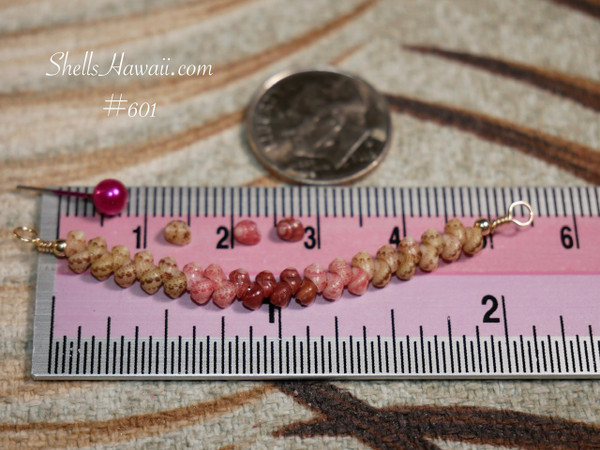 pd_601
Genuine Kahelelani shell necklace from Niʻihau shown beside a ruler for size reference featuring natural green, pink flower, and deep red burgundy shell colors in a refined minimalist design.