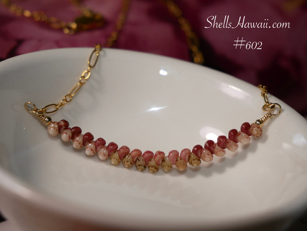 pd_602
Authentic Hawaiian shell necklace from Niʻihau displayed in a white dish featuring a graceful curved arrangement of genuine Kahelelani shells with elegant minimalist coastal style.