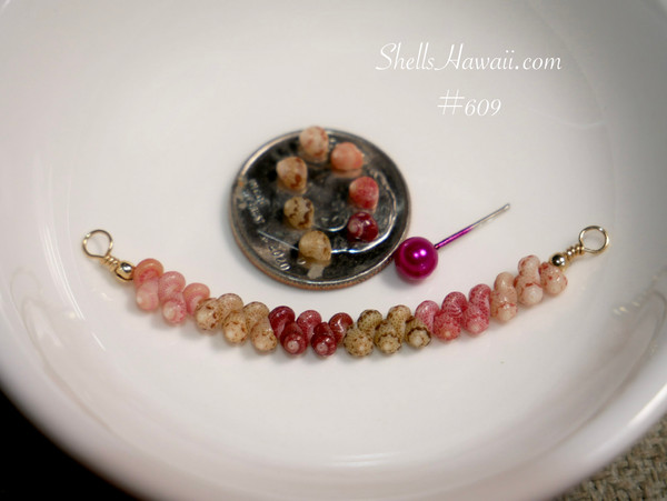 pd_609
Authentic Hawaiian shell necklace from Niʻihau displayed in a white ceramic dish featuring a soft ombré arrangement of genuine Kahelelani shells in a minimalist curved floating shell necklace design.