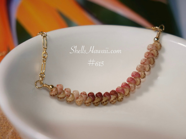 pd_615
Close-up overall view of the minimalist shell pendant resting inside a white ceramic dish highlighting the soft color flow, curved shell pattern, and detailed handcrafted workmanship of genuine Kahelelani shells from Niʻihau in green, Keʻokeʻo, red burgundy, and pink tones.