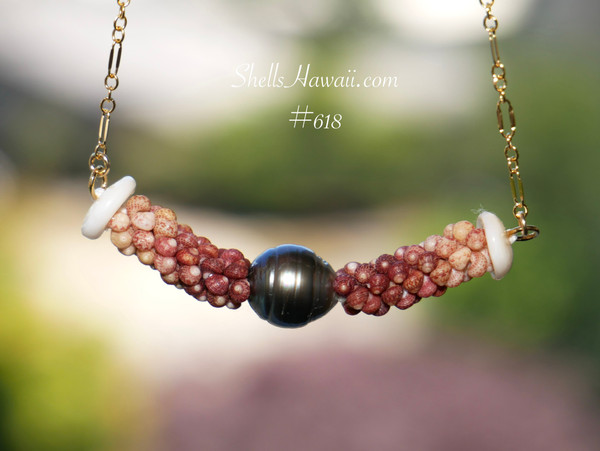 pd_618
Hanging view of a triple strand poepoe Kahelelani shell necklace featuring a round baroque silver tone Tahitian pearl centerpiece surrounded by tightly woven burgundy and brown ombré Kahelelani shells from Kauaʻi showcasing the curved floating design and detailed Hawaiian shell workmanship.