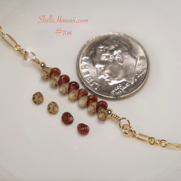 bl_706
Authentic Hawaiian shell bracelet displayed beside a dime showing the tiny scale and natural beauty of genuine Kahelelani shells in ʻōmaʻomaʻo green and mākuʻe brown tones accented with 14k gold filled chain. Delicate handcrafted Niʻihau shell jewelry with minimalist coastal elegance.