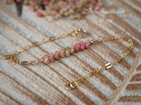 bl_709
Minimalist Hawaiian shell bracelet featuring genuine Kahelelani shells from Niʻihau arranged in a pink ombré floating design with ʻākala pua pink flower shells blended with ʻōmaʻomaʻo green and keʻokeʻo tones. Delicate handcrafted island jewelry displayed against a tropical palm leaf background with elegant coastal inspired style.