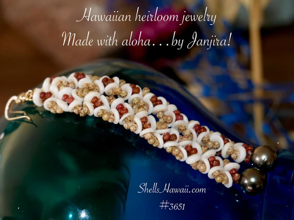 Full view of 3 1/2" Kahelelani and Puka shell flower-inspired earrings displayed on a blue glass vase with dried flowers, featuring peacock Tahitian pearls and genuine Hawaiian shells, making a beautiful Hawaiian shell jewelry gift.