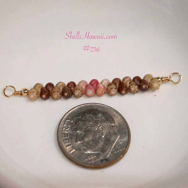 pd_736
Close-up of genuine Niʻihau Kahelelani shells in green, dark brown, Keʻokeʻo white, pink flower and hot pink, arranged for a dainty Hawaiian bar necklace and shown beside a dime for size comparison.