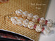 2 ½″ Niʻihau Momi crown flower earrings featuring light yellow Lenalena shells with delicate pink ʻĀkala Pua Kahelelani accents. Genuine Hawaiian shell jewelry with soft pastel glow.