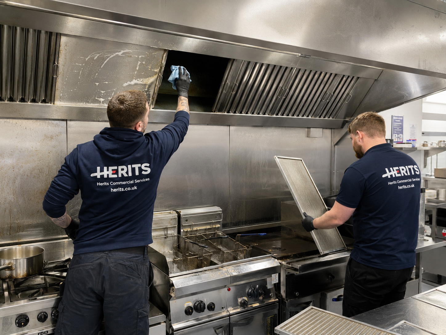 Herits employees deep cleaning a commercial kitchen extraction canopy